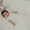 Bebé acostado con saco pijama de verano 0-6 meses con estampado de cometas, en algodón orgánico de Sonpetit Barcelona.